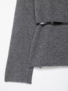Detailed view of gray wool knit jacket hem with a slim black leather belt waist detail