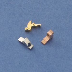Close-up of flamingo pendants in gold, rose gold and silver finishes on blue surface