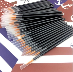 Detailed shot of fine eyeliner brushes with orange nylon tips and clear protective caps