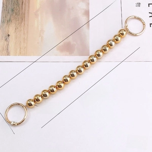 Macro detail of 240mm golden bead chain accessory for clogs with dimension specifications