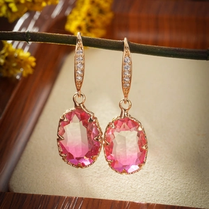 Elegant rose gold drop earrings with oval gradient gemstone and zircon accents on wood