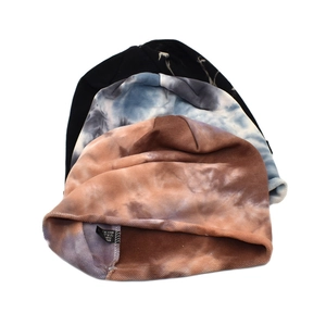 Three tie-dye knitted slouchy beanies in black, blue-grey, and brown stylish stack