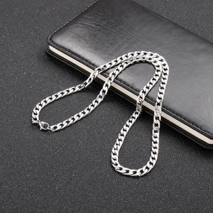 Close-up of silver Cuban link chain with lobster clasp on a black textured background
