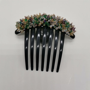Detail of colorful crystal beads and handmade wire wrapping on a black hair comb accessory