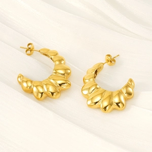 Textured gold C-shape croissant earrings in stainless steel on white fabric background