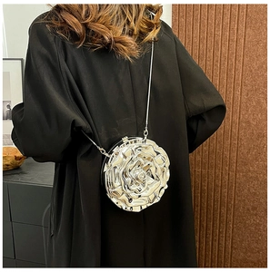 Detailed view of silver 3D rose-shaped PVC handbag with metallic chain strap on model