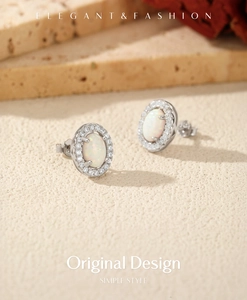 Macro detail of silver oval opal stud earrings with a cubic zirconia halo setting