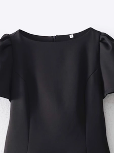 Detail of a black off-shoulder dress with puff sleeves, S-size tag and hidden back zipper