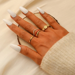 Close-up of a 5-piece gold titanium ring set with crown and moon motifs on a hand