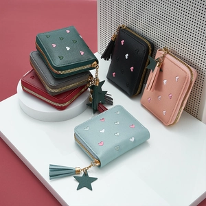 Detail of short wallets with heart embroidery, star charms, and tassels in six colors