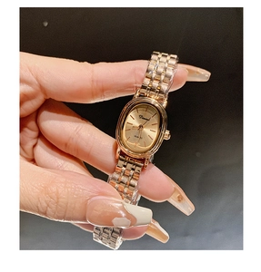 Detailed view of women's rose gold oval watch with quartz movement and metal chain strap