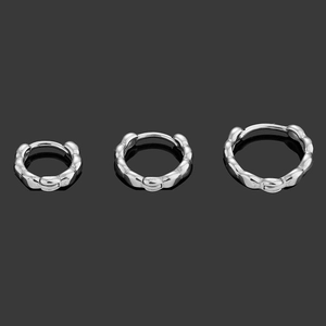 Three sizes of silver 316L stainless steel twist hoop earrings on a dark grey background