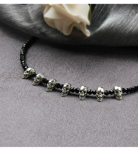Detail of Gothic skull necklace featuring silver pendants and black faceted crystal beads