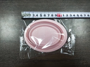 Pink silicone makeup brush cleaning bowl shown with measuring tape for size reference