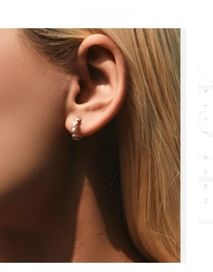 Detail of pink heart dangle earrings in S925 silver worn by a model for a sweet look