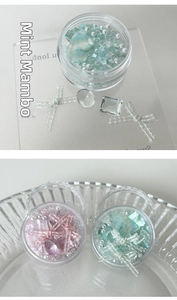 Detail of mint green and light pink crystal nail art mix with shells and pearls