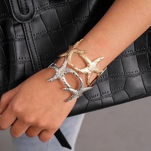 Detailed shot of starfish cuff bracelet with hammered metal texture on woman wrist