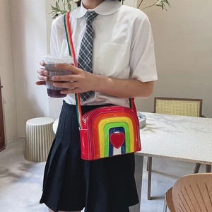 Detailed view of rainbow crossbody bag with heart ornament and adjustable strap