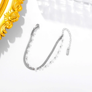 Elegant silver layered bracelet with snake chain and white pearls on white background