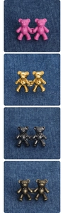 Detail view of bear-shaped adjustable waist buckles in four colors on denim fabric