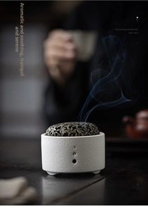 Detail of zen ceramic incense burner with hollow leaf lid and rising smoke effect