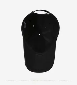 Detail view of the black cotton baseball cap interior with wash label and adjustable strap
