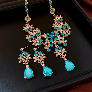Detail of floral jewelry set with blue gemstones and crystals on black display tray