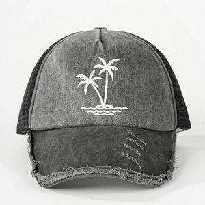 Close-up of distressed brim on washed gray trucker hat with white coconut tree embroidery