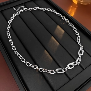 Detailed close-up of a silver metal chain necklace with sparkling cubic zirconia links
