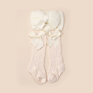 Détail du bandeau tricoté pour bébé et chaussettes à nœuds ajourées et respirantes