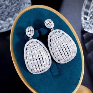 Detail showing high-quality white zircon inlay on silver geometric drop earrings