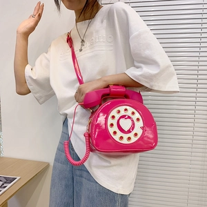 Detail of creative phone-shaped crossbody bag in bright fuchsia patent leather for women