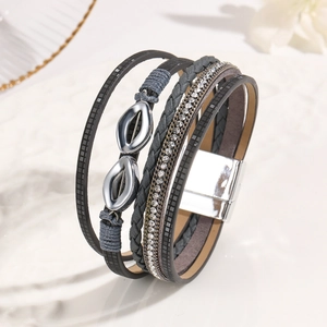Detail of bohemian multilayer leather bracelet with rhinestones and silver infinity charm