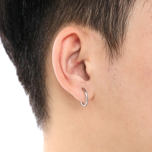 Sleek silver stainless steel round hoop earrings worn by a model in a minimalist style