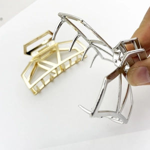 Detail of gold and silver geometric metal hair claws showing internal spring and structure