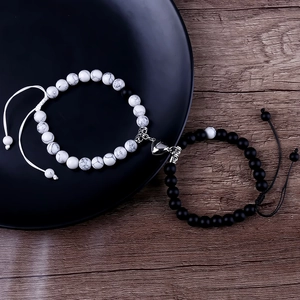 Close-up of magnet heart clasp connecting black and white natural stone bracelets