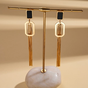 Détail de boucles d'oreilles à pampilles plaquées or 18K avec carré noir sur un présentoir