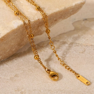 Exquisite 18K gold-plated titanium bead chain bracelet with lobster clasp on stone surface