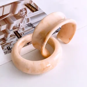 Set di bracciali minimalisti in resina marmorizzata crema e marrone su rivista di moda