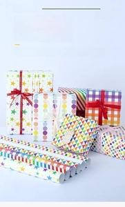 Close-up of colorful gift wrapping paper featuring stars, dots, and geometric patterns