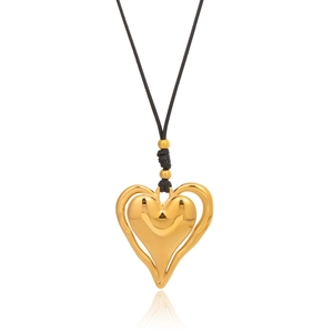 Détail macro d'un pendentif cœur doré à double couche sur un collier en cordon noir