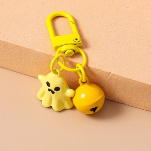 Close-up of yellow 3D cartoon ghost keychain with matching bell and metal ring