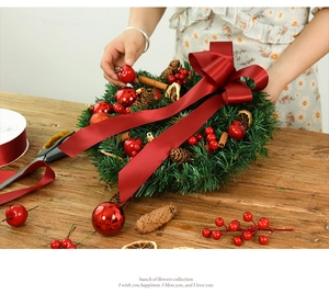 Detailed Christmas wreath with red ribbon, pine cones and berries on a rustic wood background