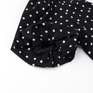 Detailed view of elastic cuffs on a vintage black and white polka dot dress sleeve