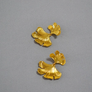 Detailed view of dual-layered ginkgo leaf earrings with fine golden texture and veins