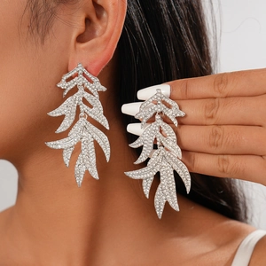 Boucles d'oreilles vintage en forme de feuille avec strass portées par un mannequin