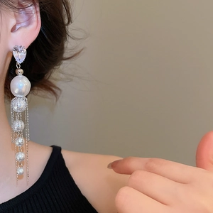 Vue détaillée de longues boucles d'oreilles perles et zircon sur chaîne argentée
