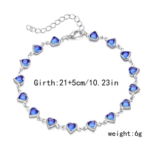 Detailed view of silver bracelet featuring multiple blue heart-shaped cubic zirconia gems
