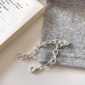 Elegant 925 sterling silver chain bracelet with oval links on minimalist grey fabric