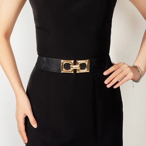 Women's black elastic wide belt with golden geometric buckle on black dress